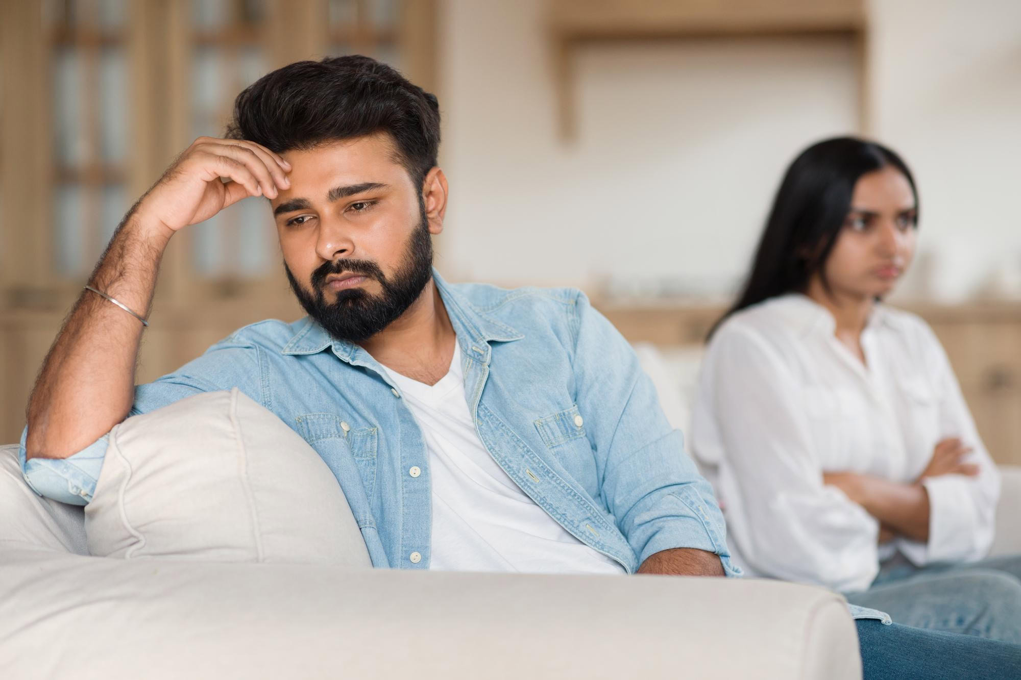 Feeling stressed or anxious, young man with headache in a mental health counseling session.